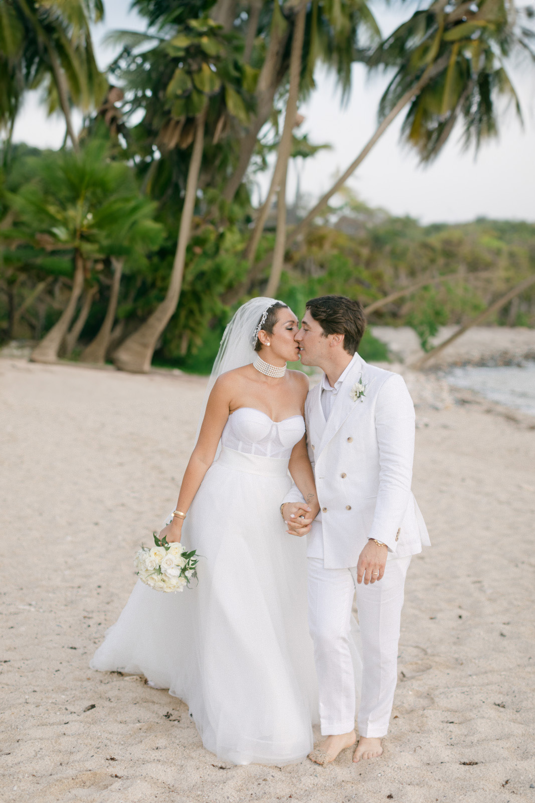 St Barts Beach Wedding: Couple's kiss under palm trees