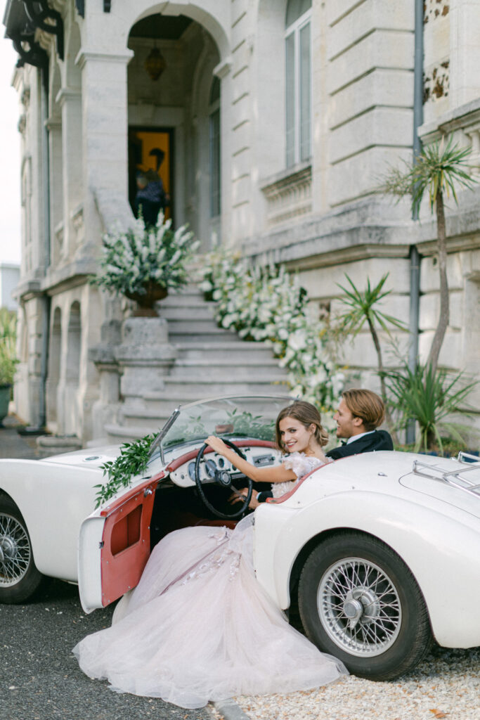 Bride and groom in a vintage car, epitomizing Chateau Mader elegance