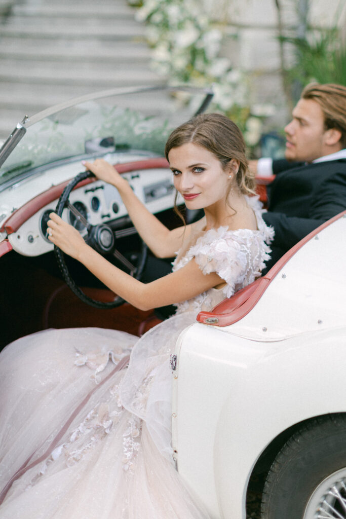 Bride and groom in a vintage car, epitomizing Chateau Mader elegance