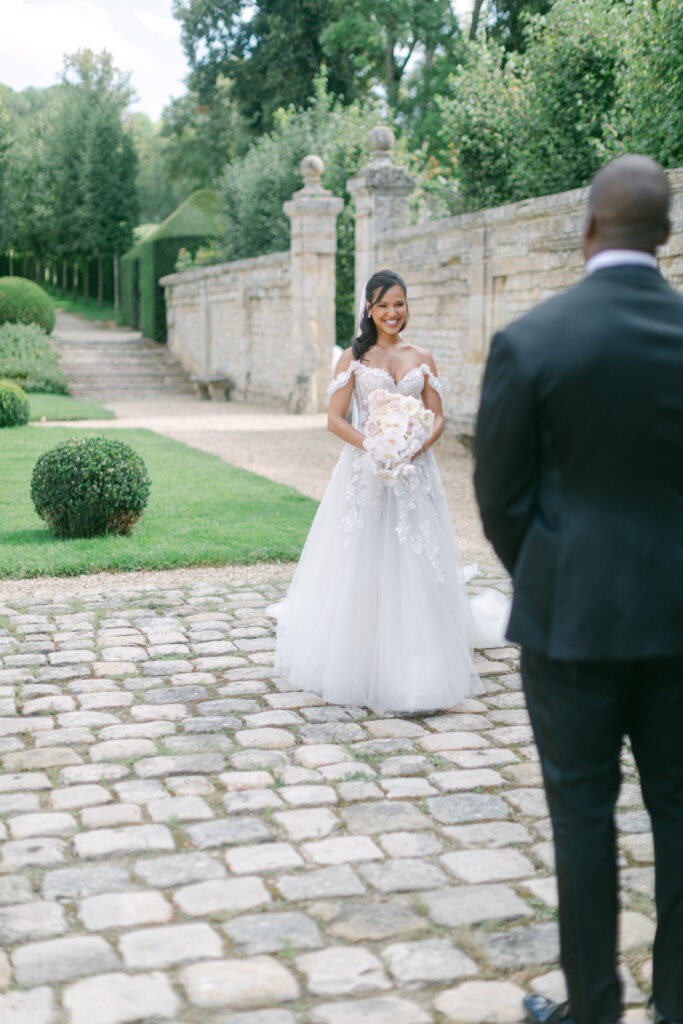 The first look, set against the backdrop of Chateau de Villette's grandeur, captures a timeless moment of love and anticipation, befitting their Parisian wedding elegance