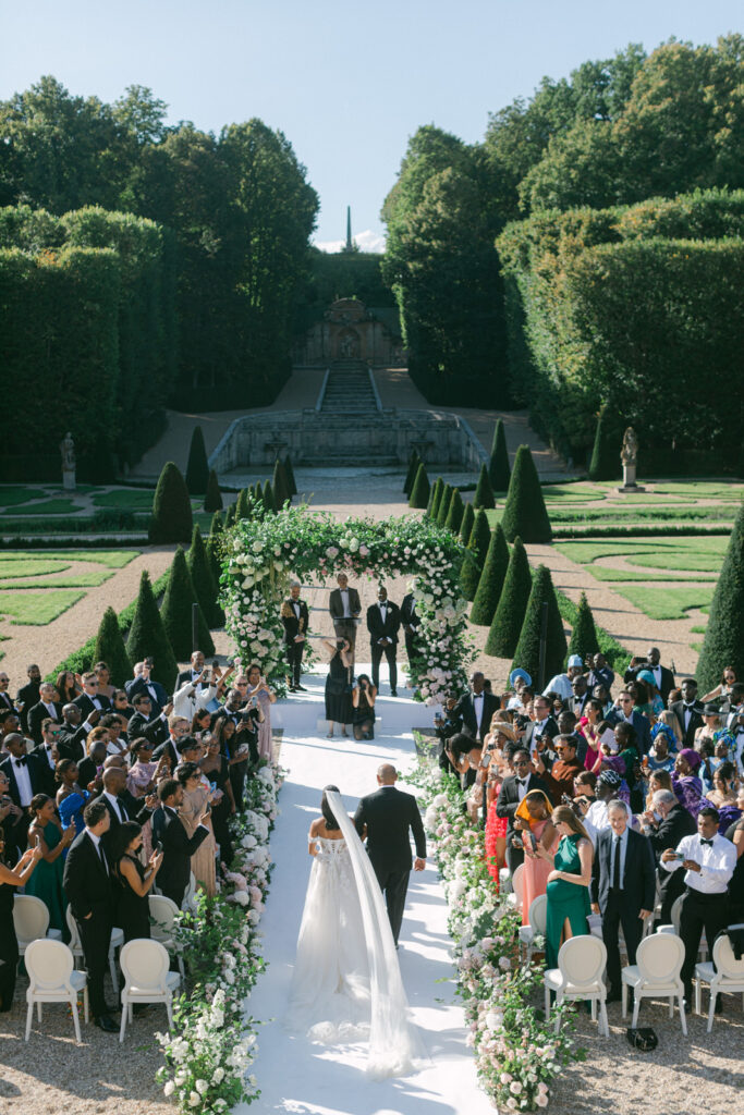 The air is filled with romance as the ceremony of 'Chateau de Villette: An Elegant Parisian Wedding' begins, set against the majestic backdrop of Chateau de Villette