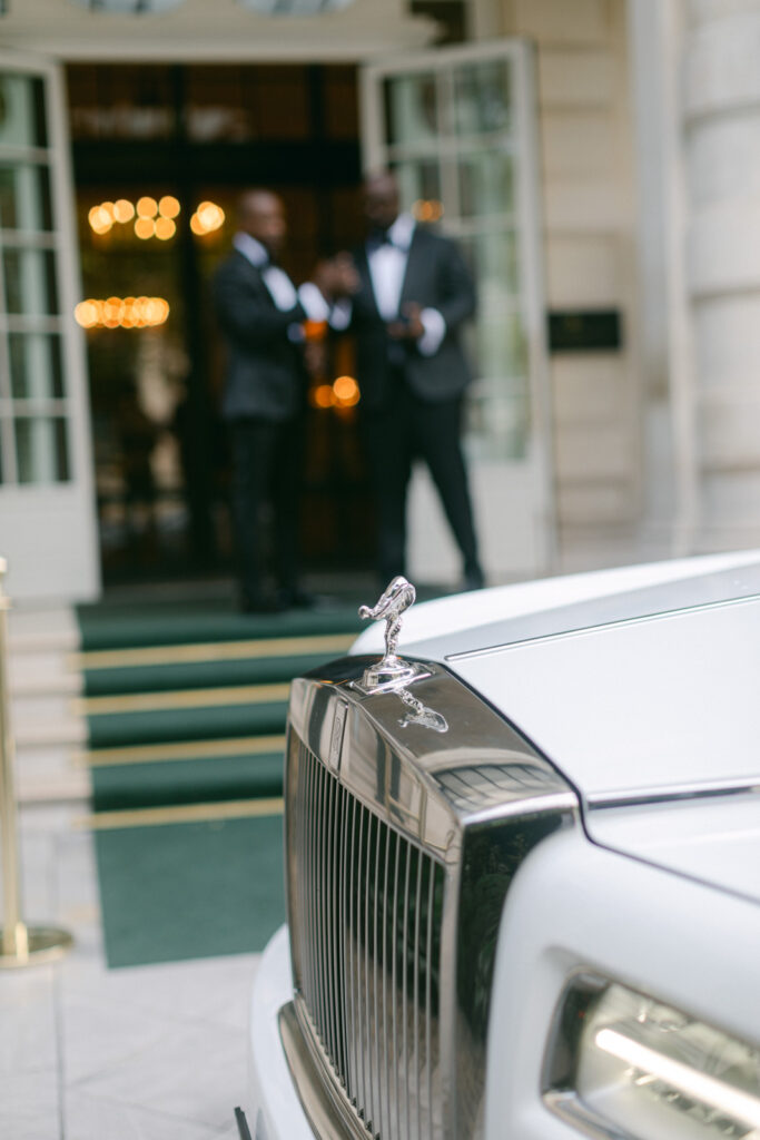 The groom makes a grand departure from the palace, elegantly seated in a Rolls-Royce, embarking towards the majestic 'Chateau de Villette' wedding