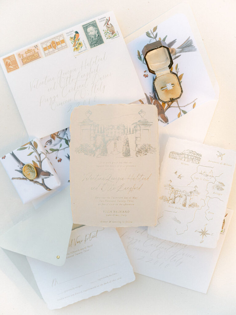 An elegant flatlay of the wedding invitations, rings, and delicate floral arrangements, capturing the refined details of a Luxury Balbiano Wedding