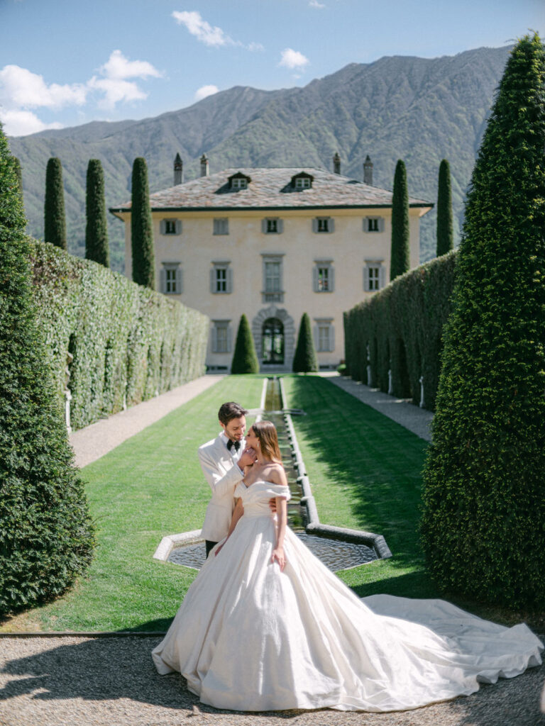 A couple shares a tender moment in the lush gardens of Villa Balbiano, epitomizing the romance of a Luxury Balbiano Wedding