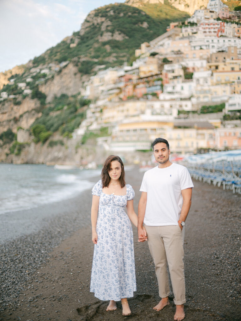 A sunset kiss by the beach, with the iconic cliffs of Positano framing the perfect moment of their honeymoon in Positano.