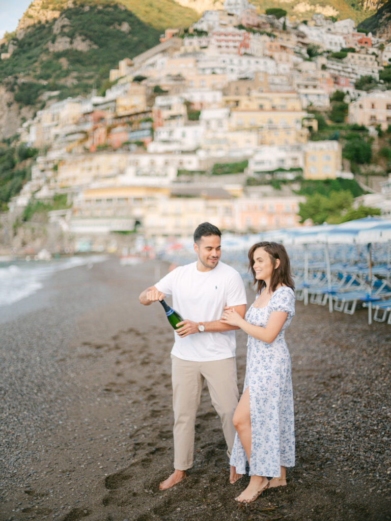 A sunset kiss by the beach, with the iconic cliffs of Positano framing the perfect moment of their honeymoon in Positano.