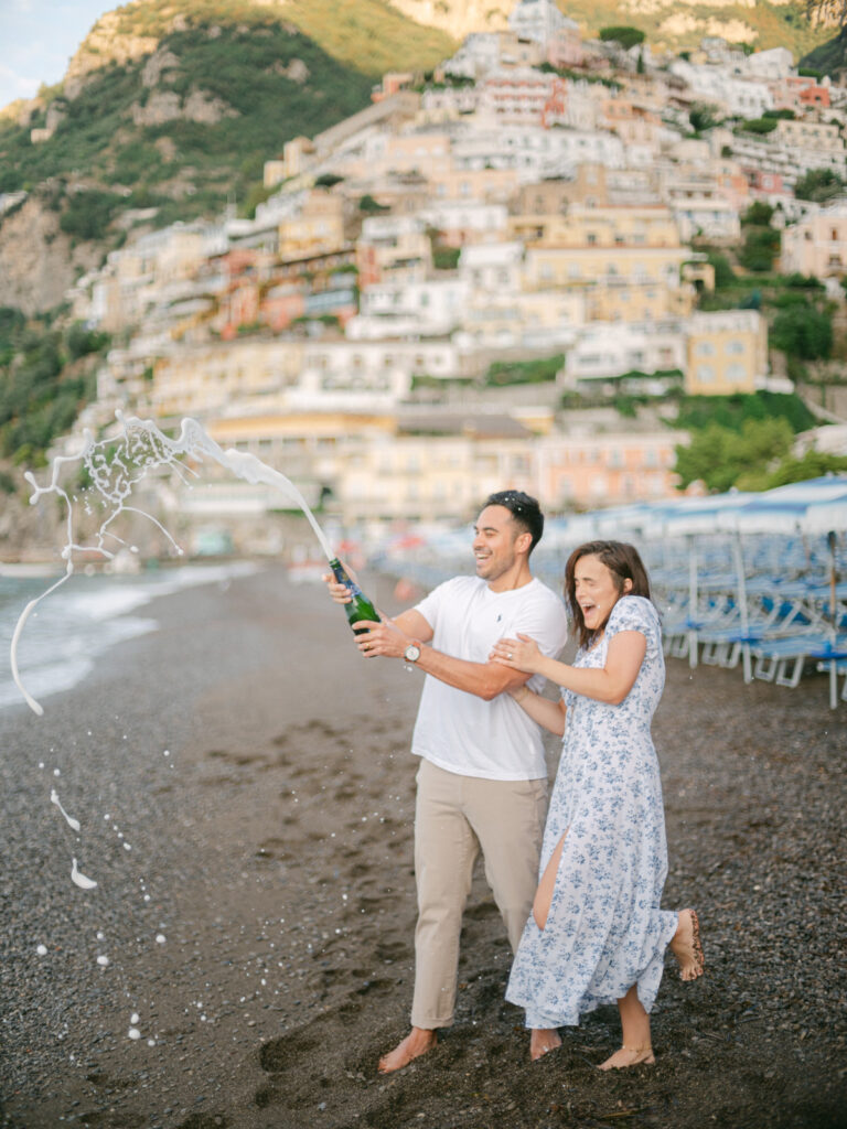 A sunset kiss by the beach, with the iconic cliffs of Positano framing the perfect moment of their honeymoon in Positano.