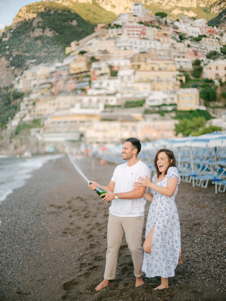 A sunset kiss by the beach, with the iconic cliffs of Positano framing the perfect moment of their honeymoon in Positano.