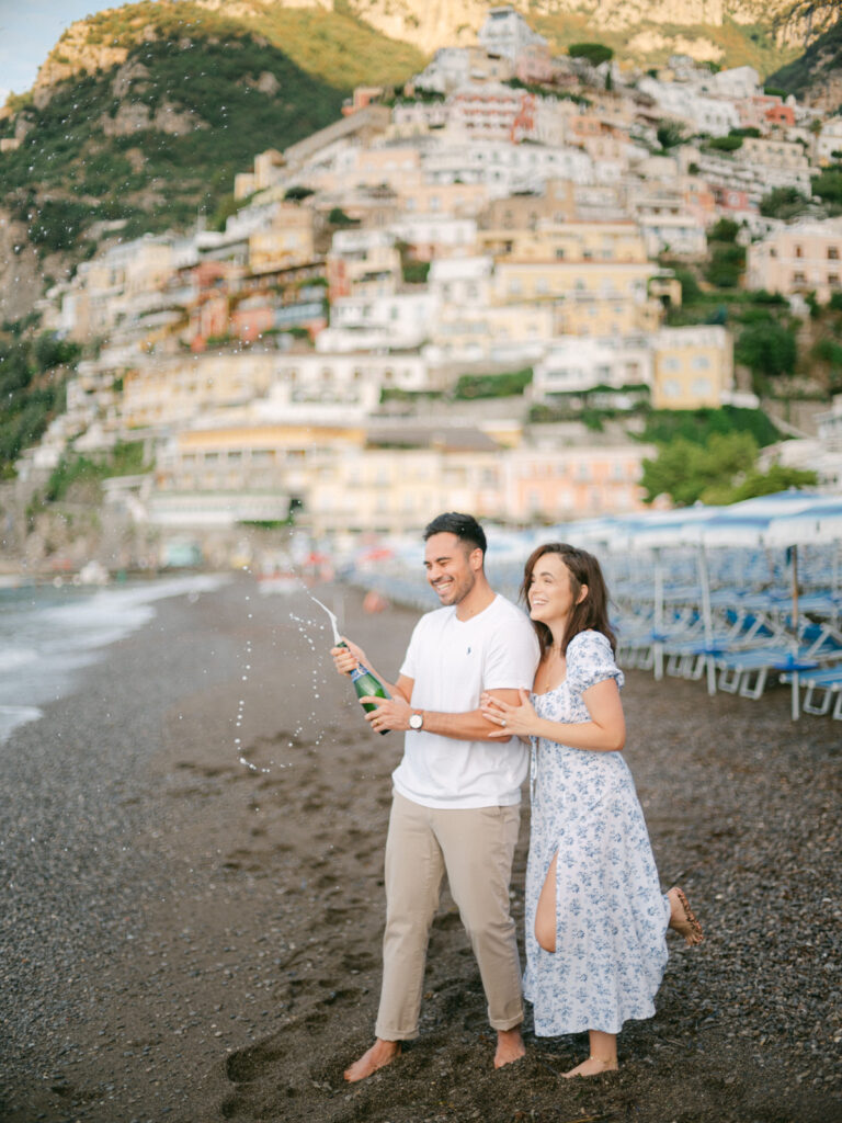 A sunset kiss by the beach, with the iconic cliffs of Positano framing the perfect moment of their honeymoon in Positano.