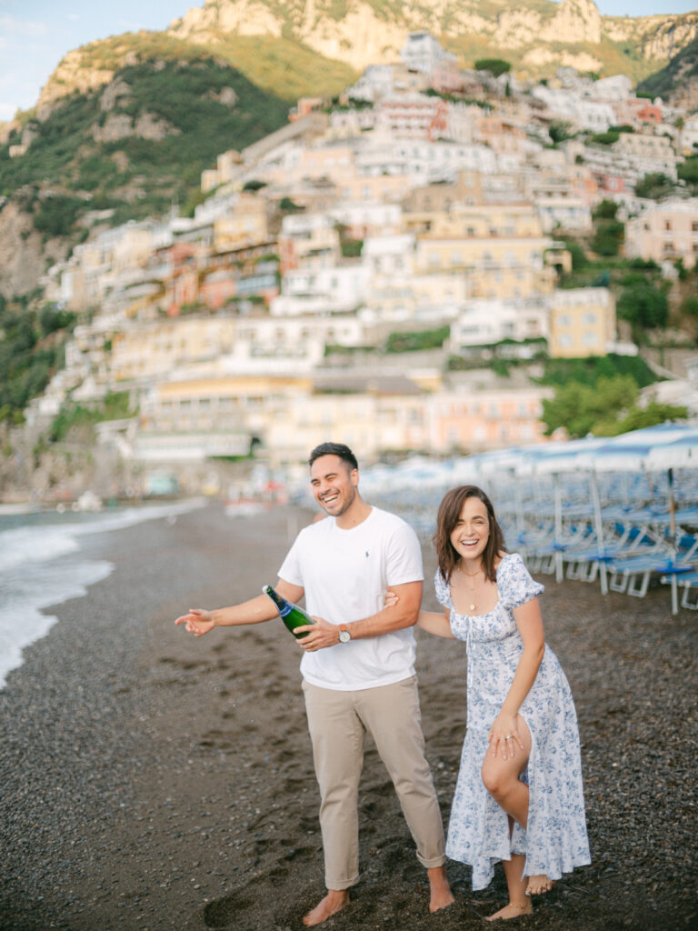 A sunset kiss by the beach, with the iconic cliffs of Positano framing the perfect moment of their honeymoon in Positano.