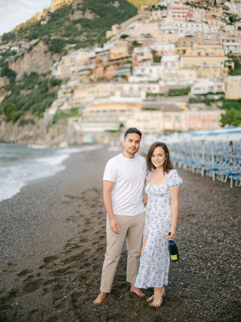 A sunset kiss by the beach, with the iconic cliffs of Positano framing the perfect moment of their honeymoon in Positano.