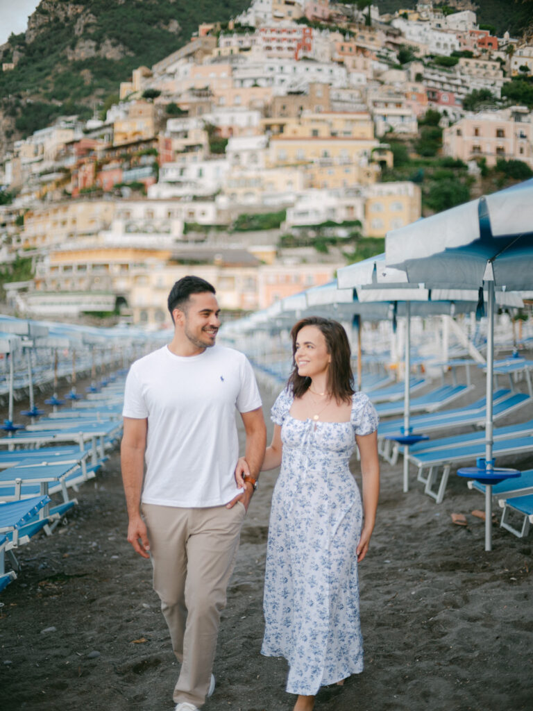 Honeymoon in Positano: A couple embraces on a sun-drenched terrace, with the colorful cliffs of Positano and the sparkling Mediterranean in the background.