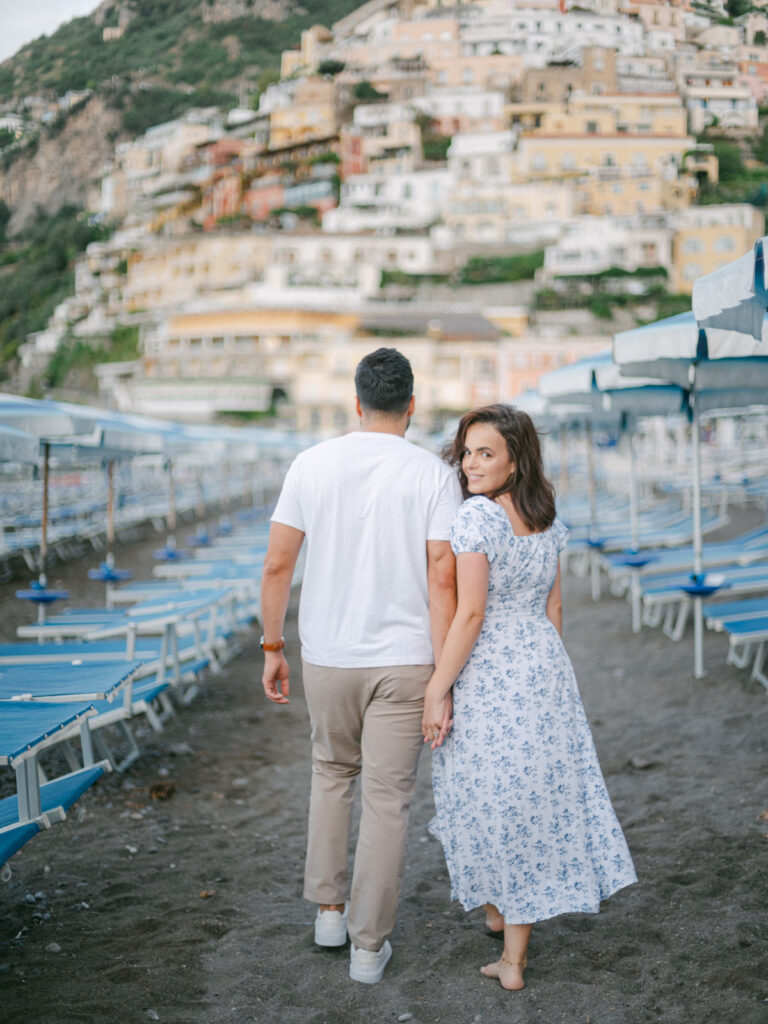 Capturing the magic of their honeymoon in Positano, the couple enjoys a quiet moment by the turquoise waters of the Amalfi Coast.