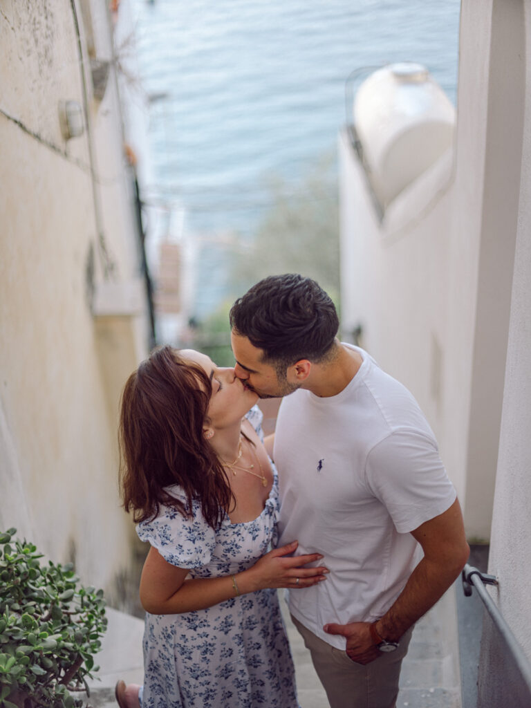 Romantic stroll through the charming streets during their honeymoon in Positano, with vibrant flowers cascading from the buildings.