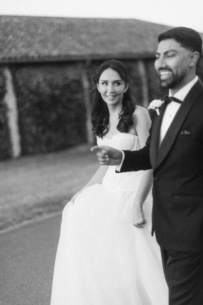 bride and groom walking through vineyard at Chateau de Seguin