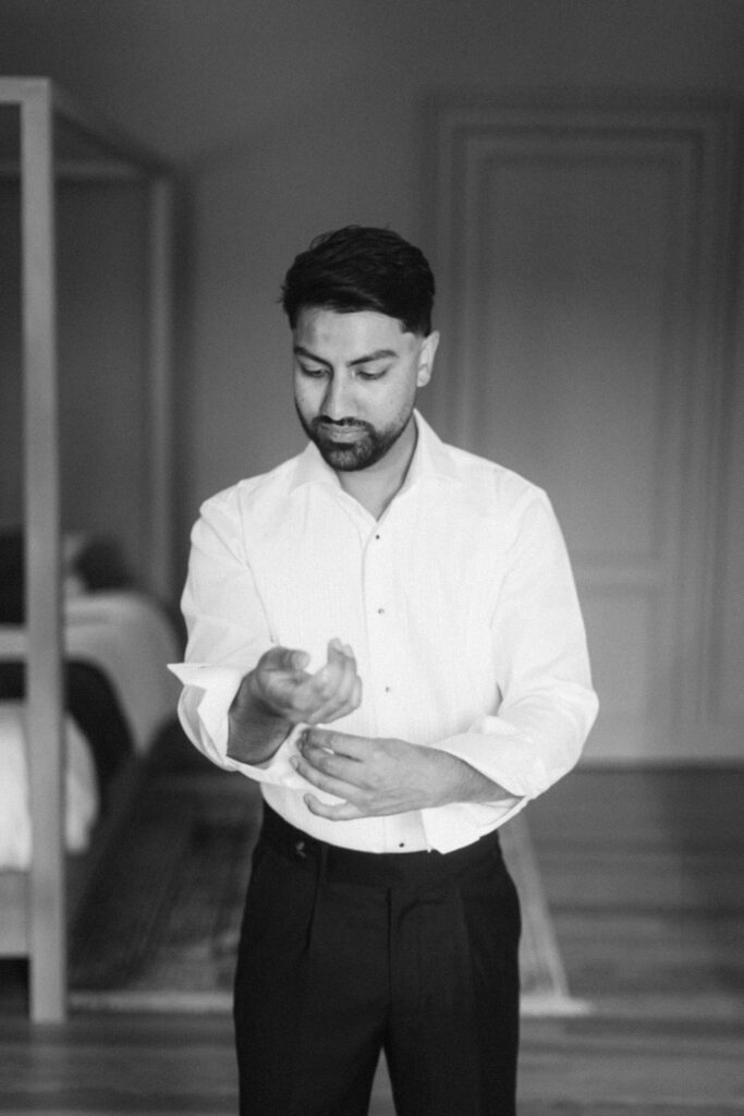 groom adjusting suit at Château de Seguin wedding