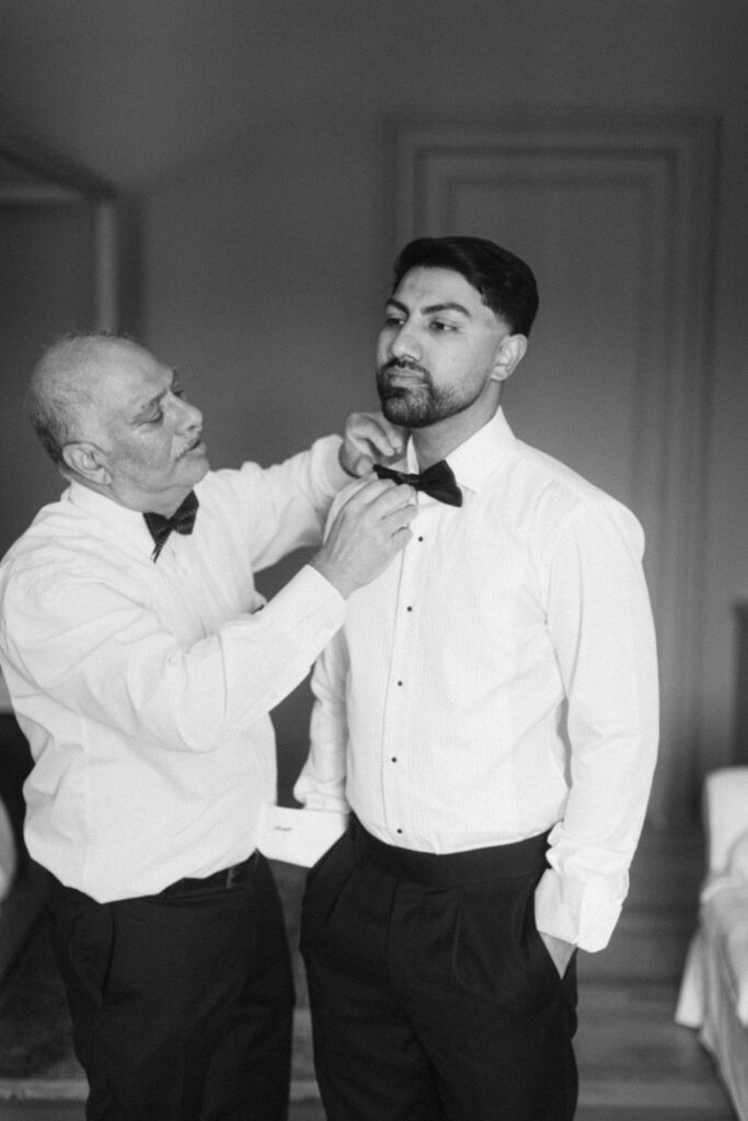 Groom adjusting cufflinks before ceremony at Château de Seguin