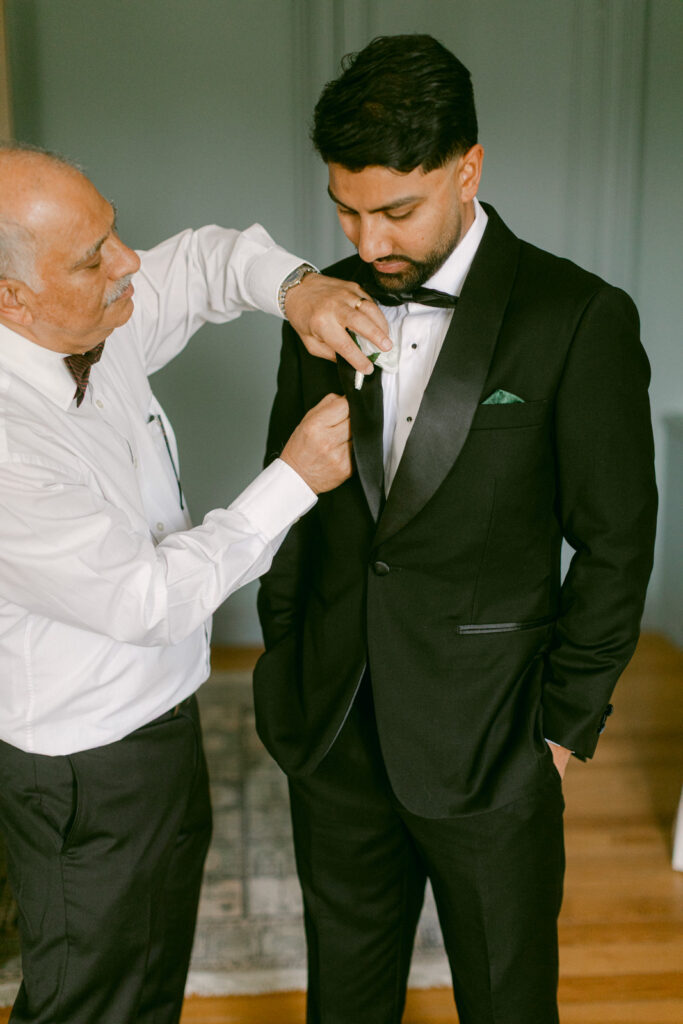 groom adjusting suit at Château de Seguin wedding